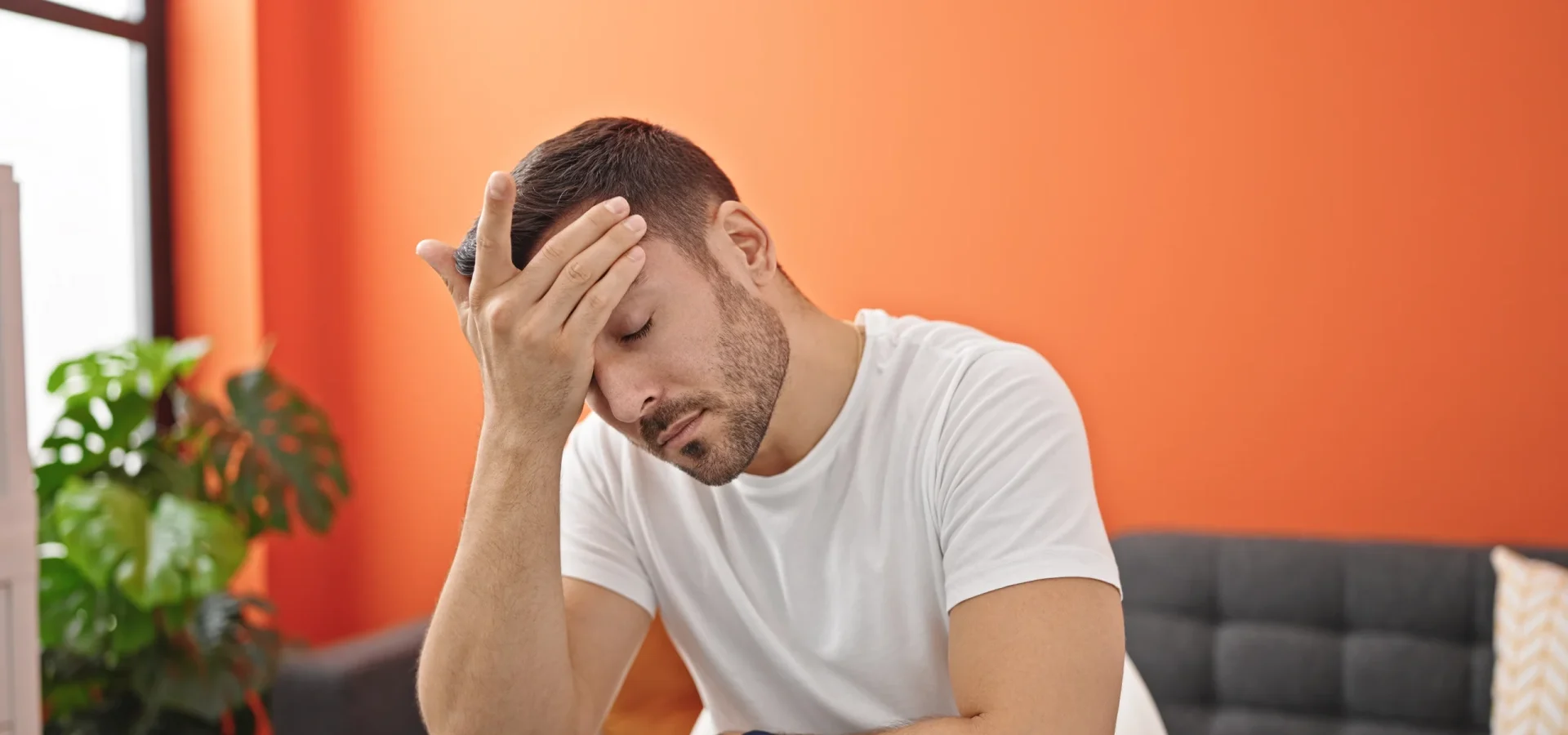 young-hispanic-man-suffering-headache-sitting-table-dinning-room